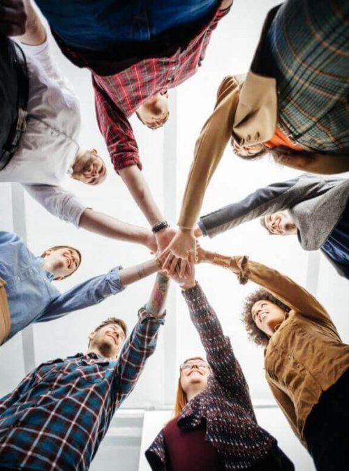 une équipe de collaborateurs joints ses mains en forme d'étoile pour symboliser l'unité et l'harmonie dans le travail d'équipe